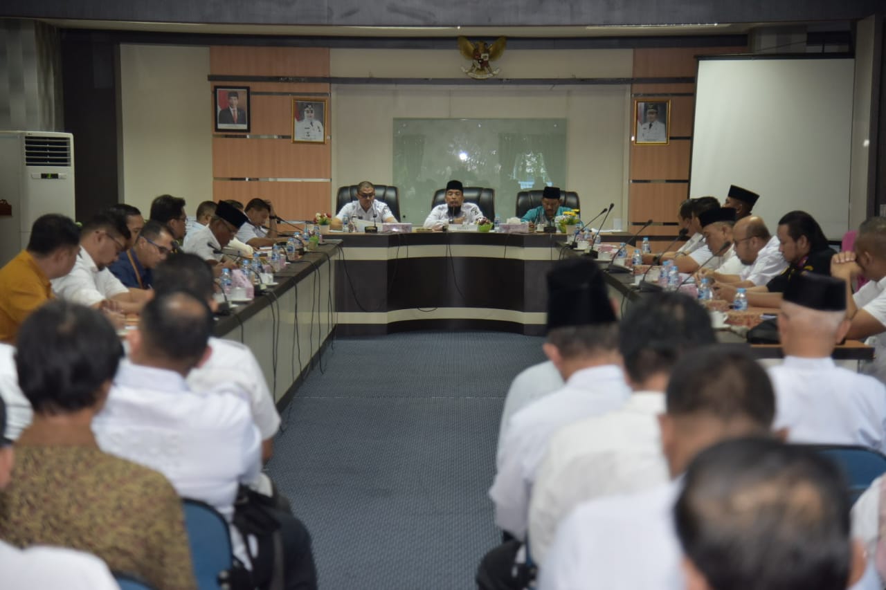 Bupati Bengkalis, sebagai pemimpin daerah, memiliki tanggung jawab penting dalam menyelenggarakan berbagai kegiatan yang berkaitan dengan urusan masyarakat, termasuk dalam hal pemberangkatan Jamaah Calon Haji (JCH). Pada tahun 2024, masalah ini kembali menjadi fokus perhatian, terutama menjelang musim haji yang selalu menarik perhatian masyarakat. Rakor (Rapat Koordinasi) yang dipimpin oleh Bupati ini bertujuan untuk mematangkan persiapan pemberangkatan JCH, memastikan semua aspek yang berkaitan dengan pelaksanaan haji berjalan lancar dan sesuai dengan ketentuan yang ada. Di dalam artikel ini, kami akan membahas berbagai aspek terkait rakor yang diadakan, mulai dari tujuan dan agenda rakor, tantangan yang dihadapi, hingga harapan masyarakat terhadap pelaksanaan haji tahun ini. 1. Tujuan dan Agenda Rakor Pemberangkatan JCH Rakor yang dipimpin oleh Bupati Bengkalis bertujuan untuk menyusun rencana yang komprehensif terkait pemberangkatan Jamaah Calon Haji (JCH) pada tahun 2024. Pertemuan ini penting untuk mengkoordinasikan berbagai pihak, termasuk Kementerian Agama, Dinas Kesehatan, Dinas Perhubungan, serta instansi terkait lainnya. Beberapa agenda yang dibahas dalam rakor meliputi: Pendaftaran dan Seleksi JCH: Proses pendaftaran Jamaah Calon Haji akan diatur dengan ketat untuk memastikan bahwa hanya mereka yang memenuhi syarat yang akan berangkat. Dalam rakor ini, dibahas pula mengenai sistem pendaftaran yang akan digunakan, apakah melalui online atau offline. Pelayanan Kesehatan: Kesehatan Jamaah menjadi salah satu prioritas utama. Dinas Kesehatan diharapkan dapat memberikan layanan kesehatan yang optimal, termasuk pemeriksaan kesehatan sebelum keberangkatan, vaksinasi, dan layanan kesehatan di tanah suci. Transportasi dan Akomodasi: Aspek transportasi dan akomodasi juga menjadi topik krusial dalam rakor. Bupati menekankan pentingnya kerja sama dengan Dinas Perhubungan untuk mengatur transportasi yang nyaman dan aman bagi JCH, serta memastikan akomodasi yang memadai saat di tanah suci. Pendidikan dan Bimbingan Manasik Haji: Bimbingan manasik haji akan diselenggarakan untuk memberikan pengetahuan dan pemahaman kepada calon jemaah tentang tata cara pelaksanaan ibadah haji. Hal ini sangat penting agar semua JCH dapat melaksanakan ibadah dengan baik dan benar. Melalui rakor ini, diharapkan semua pihak dapat saling berkolaborasi untuk memberikan yang terbaik bagi Jamaah Calon Haji, sehingga pelaksanaan ibadah haji tahun 2024 dapat berjalan dengan sukses. 2. Tantangan dalam Pemberangkatan JCH Tahun 2024 Pelaksanaan haji selalu diwarnai dengan berbagai tantangan, dan tahun 2024 tidak terkecuali. Dalam rakor, Bupati Bengkalis bersama dengan instansi terkait membahas berbagai kendala yang mungkin dihadapi dalam proses pemberangkatan JCH. Beberapa tantangan yang diidentifikasi adalah: Peningkatan Jumlah Jamaah: Setiap tahun, jumlah pendaftar haji terus meningkat, yang dapat menjadi tantangan dalam hal penyediaan fasilitas dan layanan. Dengan adanya antrean yang panjang, perlu ada strategi untuk mengelola dan memprioritaskan pendaftaran JCH. Kondisi Kesehatan Jamaah: Mengingat banyaknya calon jamaah yang berusia lanjut dan memiliki riwayat penyakit, Dinas Kesehatan perlu bekerja keras untuk memastikan kondisi kesehatan mereka. Hal ini mencakup penyediaan obat-obatan, vaksinasi, dan layanan kesehatan yang memadai. Logistik dan Transportasi: Perencanaan logistik yang matang menjadi kunci untuk mengatasi tantangan transportasi. Dalam rakor, perlu dibahas mengenai rute perjalanan, jenis transportasi yang digunakan, serta durasi perjalanan agar JCH tidak mengalami kendala saat menuju bandara. Ketersediaan Akomodasi di Tanah Suci: Ketersediaan tempat menginap di Makkah dan Madinah juga menjadi perhatian. Pihak penyelenggara harus memastikan bahwa JCH mendapatkan akomodasi yang layak dan tidak terjebak dalam kondisi yang tidak nyaman. Dalam menghadapi tantangan ini, sinergi antara pemerintah daerah, instansi terkait, dan masyarakat menjadi penting. Hal ini diharapkan dapat menciptakan lingkungan yang mendukung dan memudahkan pelaksanaan ibadah haji. 3. Harapan Masyarakat Terhadap Pelaksanaan Haji Tahun 2024 Masyarakat memiliki harapan yang besar terhadap pelaksanaan haji tahun 2024. Dalam rakor yang dipimpin oleh Bupati, harapan-harapan ini disampaikan oleh berbagai perwakilan masyarakat. Beberapa harapan tersebut adalah: Transparansi dan Akuntabilitas: Masyarakat menginginkan adanya transparansi dalam proses pendaftaran dan pemberangkatan JCH. Mereka berharap bahwa semua informasi terkait biaya, fasilitas, dan pelayanan dapat diakses dengan mudah. Pelayanan yang Prima: Jamaah Calon Haji berharap mendapatkan pelayanan yang baik dari semua pihak, mulai dari proses pendaftaran hingga saat mereka berada di tanah suci. Dinas Kesehatan dan Dinas Perhubungan diharapkan dapat memberikan dukungan yang maksimal. Keselamatan dan Kesehatan: Keselamatan adalah prioritas utama bagi setiap calon jamaah. Masyarakat berharap agar semua langkah pencegahan dan penanganan kesehatan dapat dilaksanakan dengan baik, sehingga tidak ada jamaah yang mengalami masalah kesehatan selama perjalanan. Pendidikan dan Pemahaman yang Baik: Jamaah juga berharap agar mereka mendapatkan bimbingan yang memadai mengenai tata cara pelaksanaan haji. Dengan adanya pemahaman yang baik, diharapkan ibadah mereka dapat berlangsung dengan lancar. Harapan-harapan ini menjadi motivasi bagi Bupati dan instansi terkait untuk terus bekerja keras dalam mempersiapkan pelaksanaan haji tahun 2024. Dengan dukungan semua pihak, diharapkan semua harapan masyarakat dapat terwujud. 4. Peran Bupati dalam Koordinasi Pemberangkatan JCH Sebagai pemimpin daerah, Bupati Bengkalis memiliki peran yang sangat penting dalam memastikan kelancaran pemberangkatan Jamaah Calon Haji. Dalam rakor, Bupati tidak hanya sebagai pemimpin, tetapi juga sebagai mediator antara berbagai pihak terkait. Beberapa peran penting Bupati adalah: Menyusun Kebijakan yang Tepat: Bupati bertugas untuk menyusun kebijakan yang dapat mendukung pelaksanaan haji. Ini termasuk menetapkan anggaran, memfasilitasi kerjasama antarinstansi, serta mengatur jadwal pemberangkatan yang tepat. Menjalin Komunikasi yang Efektif: Bupati harus dapat menjalin komunikasi yang baik dengan berbagai pihak, termasuk dengan Kementerian Agama dan masyarakat. Melalui komunikasi yang terbuka, diharapkan semua pihak dapat menyampaikan aspirasi dan permasalahan yang ada. Memastikan Ketersediaan Fasilitas: Bupati juga bertanggung jawab untuk memastikan bahwa semua fasilitas yang dibutuhkan, baik di dalam negeri maupun di tanah suci, tersedia dengan baik. Ini termasuk berkoordinasi dengan pihak penyedia akomodasi dan transportasi. Mengawasi Pelaksanaan dan Evaluasi: Setelah proses pemberangkatan, Bupati harus tetap mengawasi pelaksanaan haji dan melakukan evaluasi. Hal ini penting untuk mengetahui apakah semua proses berjalan sesuai rencana dan untuk memperbaiki kekurangan di tahun-tahun berikutnya. Dengan peran dan tanggung jawab yang besar, Bupati Bengkalis diharapkan dapat membawa perubahan positif dalam pelaksanaan haji tahun 2024, memberikan yang terbaik bagi masyarakat.